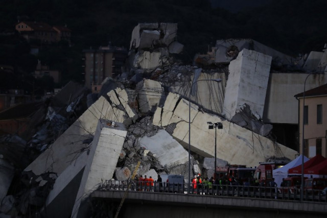 Rescuers use floodlights to inspect the rubble and search for survivors by the Morandi motorway bridge on the night of August 14, 2018. Photo: Valery Hache / AFP